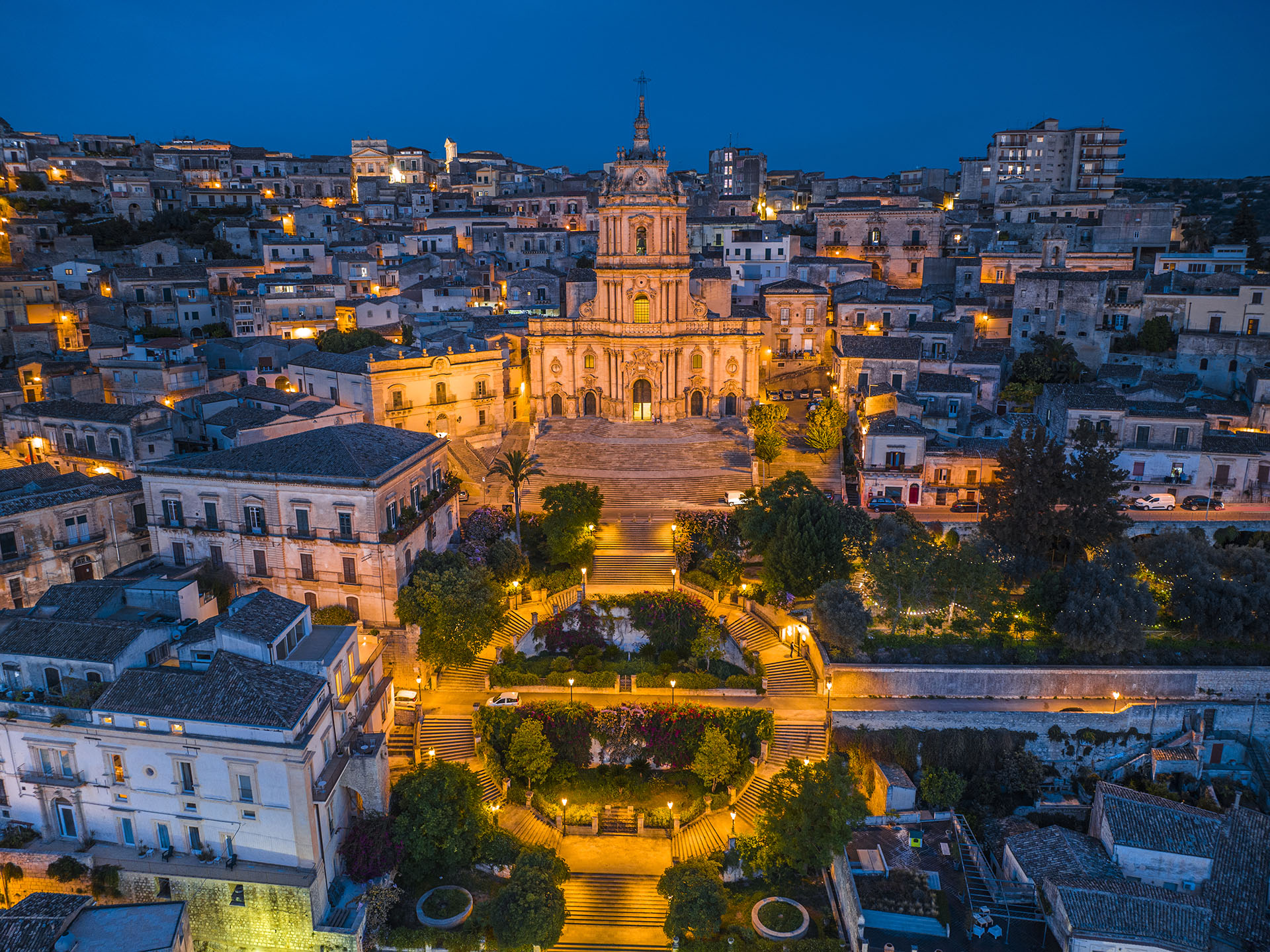 Scorcio del centro storico di Modica, con le sue case barocche arroccate sulla collina e il Duomo di San Giorgio che svetta in cima.