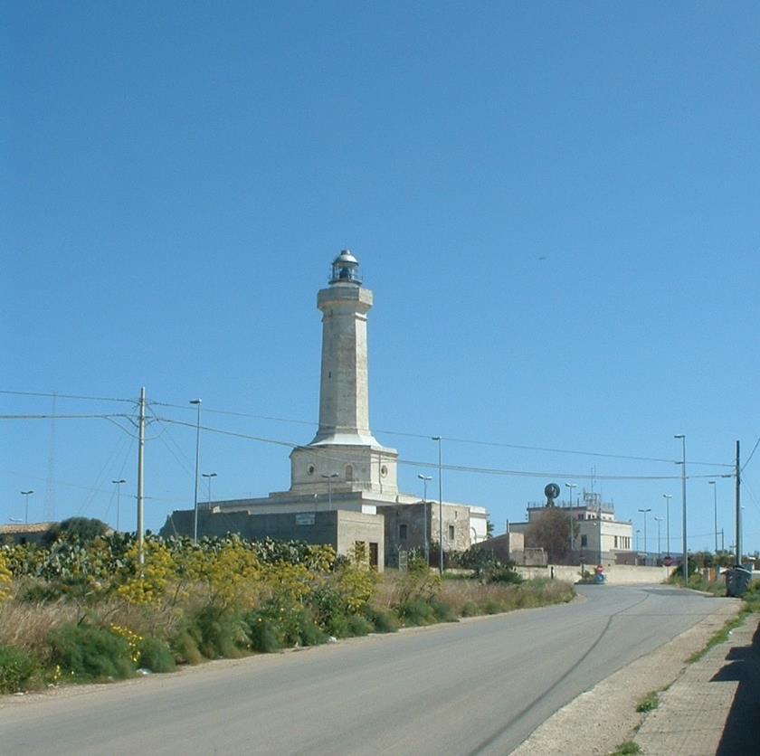 L'imponente torre bianca del Faro di Cozzo Spadaro che si erge sul promontorio roccioso.