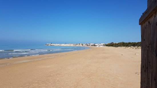 The golden beach of Sampieri dominated by the evocative silhouette of the Fornace Penna, the 'Mànnara' of Montalbano.