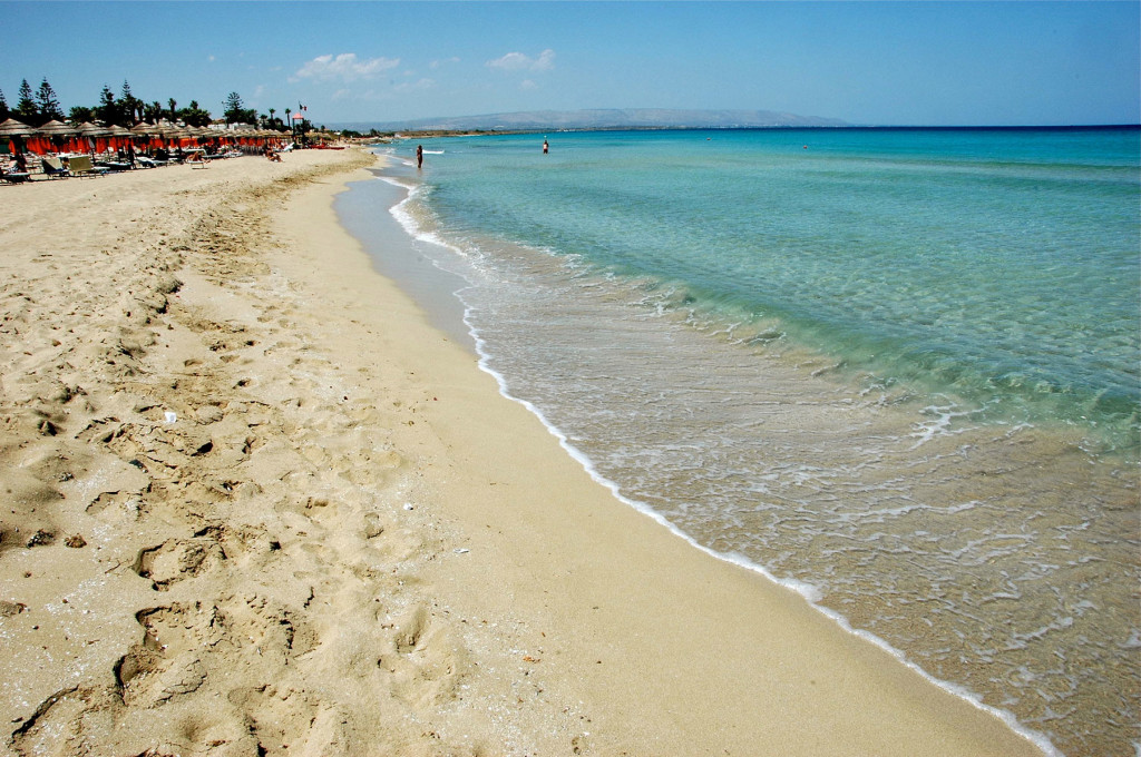 The Caribbean beach of San Lorenzo in Noto, with very white sand, shallow waters and lidos equipped with umbrellas.